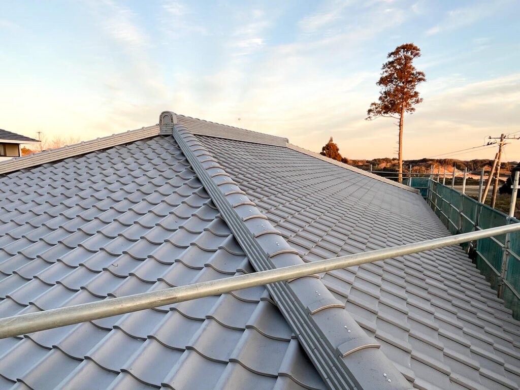 夕暮れ時に撮影された、美しく施工された銀色の瓦屋根