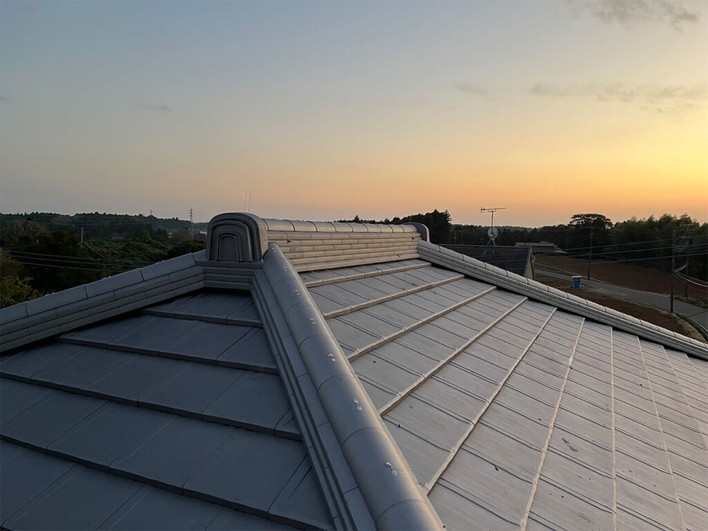 夕暮れの空を背景に、棟瓦まで丁寧に施工された平瓦屋根